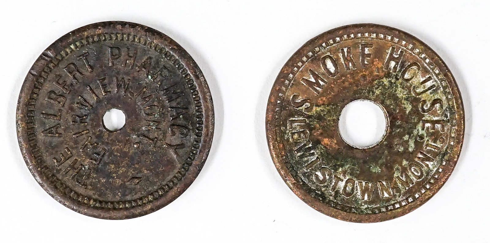 Fairview, Montana Albert Pharmacy, Lewistown: Fairview, Montana, The Albert Pharmacy round token (21 mm, G-VG, Good For 5c In Trade) and Smoke House, Lewistown, Montana (21 mm, G-VG, Good For 12.5c In Trade). If lot is absent of a condition repor