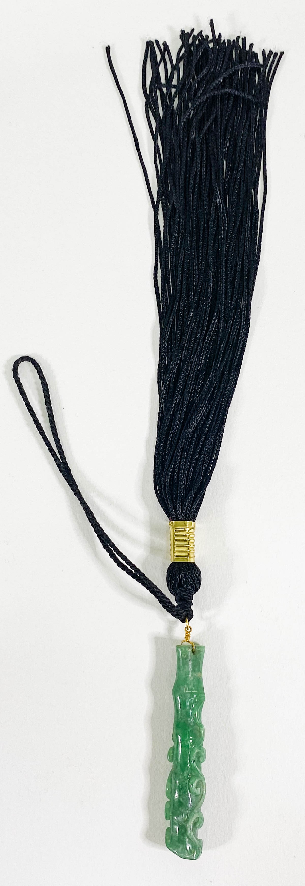 A Carved Jade with Tassel: A Carved Jade with Tassel. Jade carving measures 2.75 x .5 inches (70 mm x 13 mm). Excellent condition. If lot is absent of a condition report one may be requested via email. Condition report is provi
