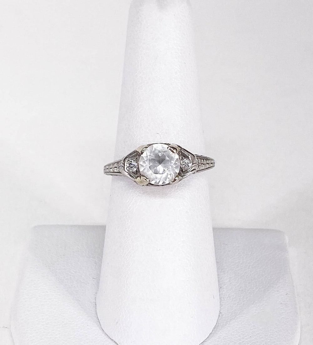 Vintage Platinum Ring: The center stone is glass, smaller stones on sides are diamonds. Weighs 3 grams. This lot requires a Wire or Zelle transfer. If lot is absent of a condition report one may be requested via email. Cond