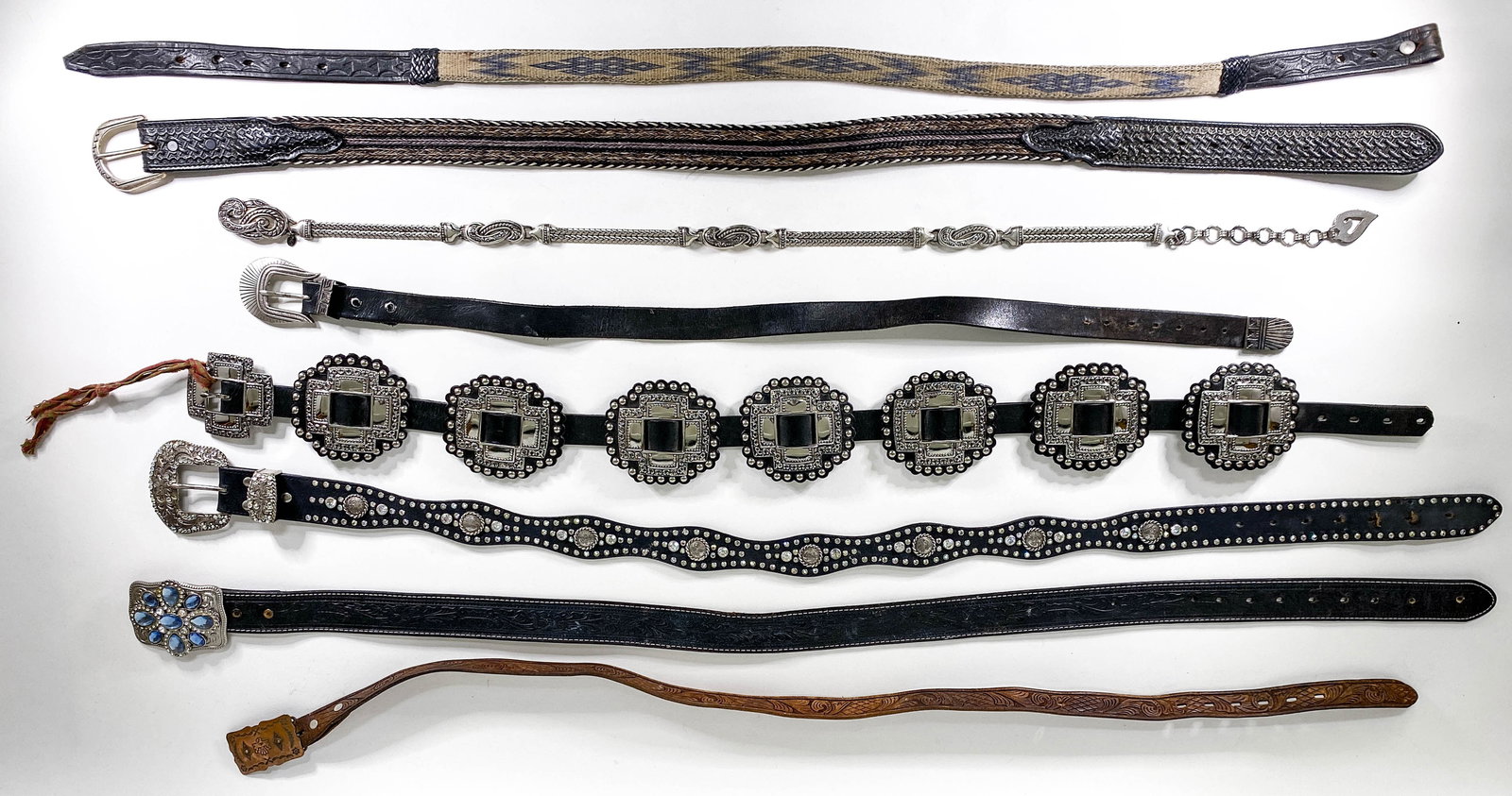 Designer Belts (8) Various Sizes: Eight (8) designer belts. Marked 32, Medium, XL and others are not marked, the silver metal belt measures 28 in. to the first link. If lot is absent of a condition report one may be requested via emai