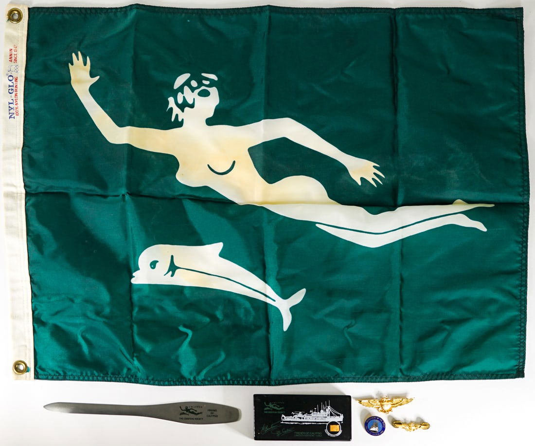 Jacques Cousteau (Calypso) Items: Jacques Cousteau (Calypso) Items. Includes a vintage Cousteau Society nylon flag measuring 18 x 25 inches, a Zippo stainless steel Friend of the Calypso letter opener measuring 9.125 inches, 1986 Frie