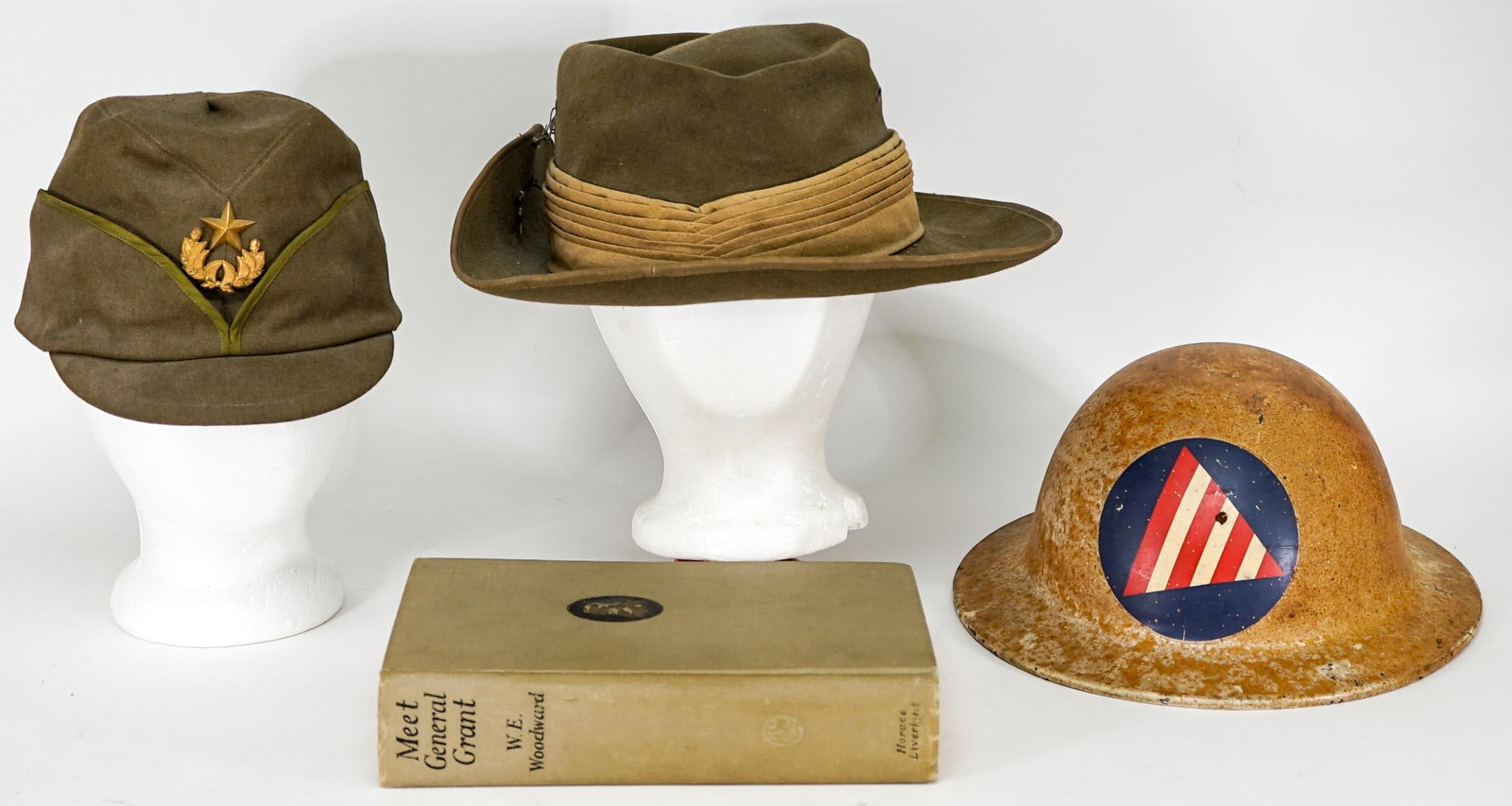 Vintage(4) Military Hats, Helmet, Book: Four (4) military hats, helmet and Meet General Grant by W. E. Woodward book. Lot measures 7 in. H x 14 in. W x 14 in. D. The absence of a condition report does not imply that the lot is in perfect co