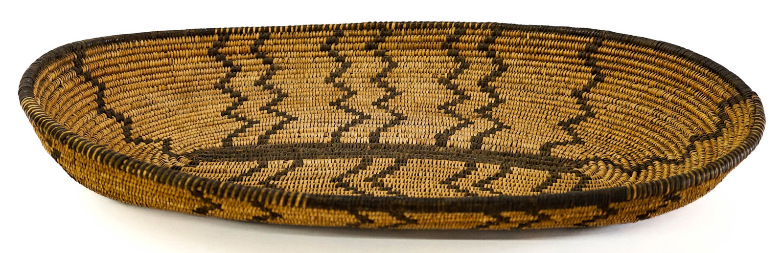 Oval 16IN Basketry Tray: Oval basketry tray. Origin unknown. Measures 16 in. x 10.25 in. Basket measures 16 in. H x 10.25 in. W x 2.25 in. D for shipping purposes only. The absence of a condition report does not imply that th