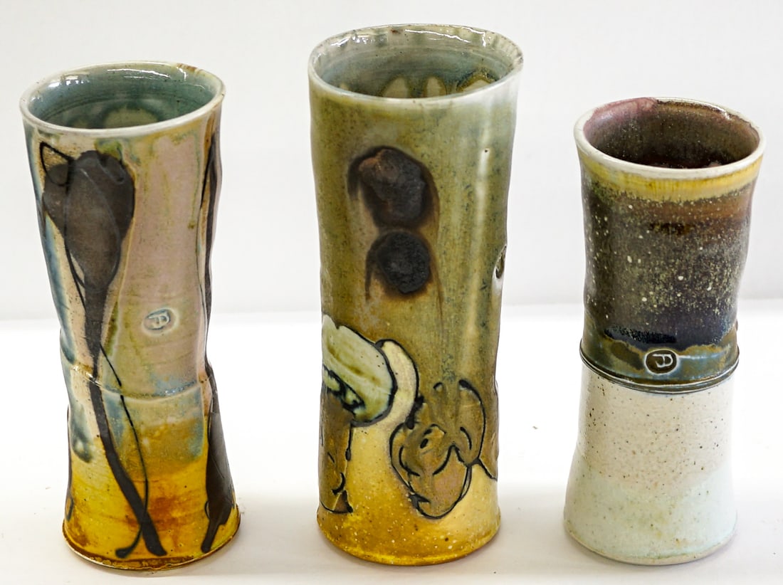 Josh DeWeese (3) Studio Pottery Vases 6-7IN: Three (3) Josh DeWeese studio pottery vases. Measure 6.25 in. to 7.25 in. tall x 2.5 in. to 2.625 in. wide. Note larger with crack repair and the mid-sized with chips at top and bottom rims. Provenanc