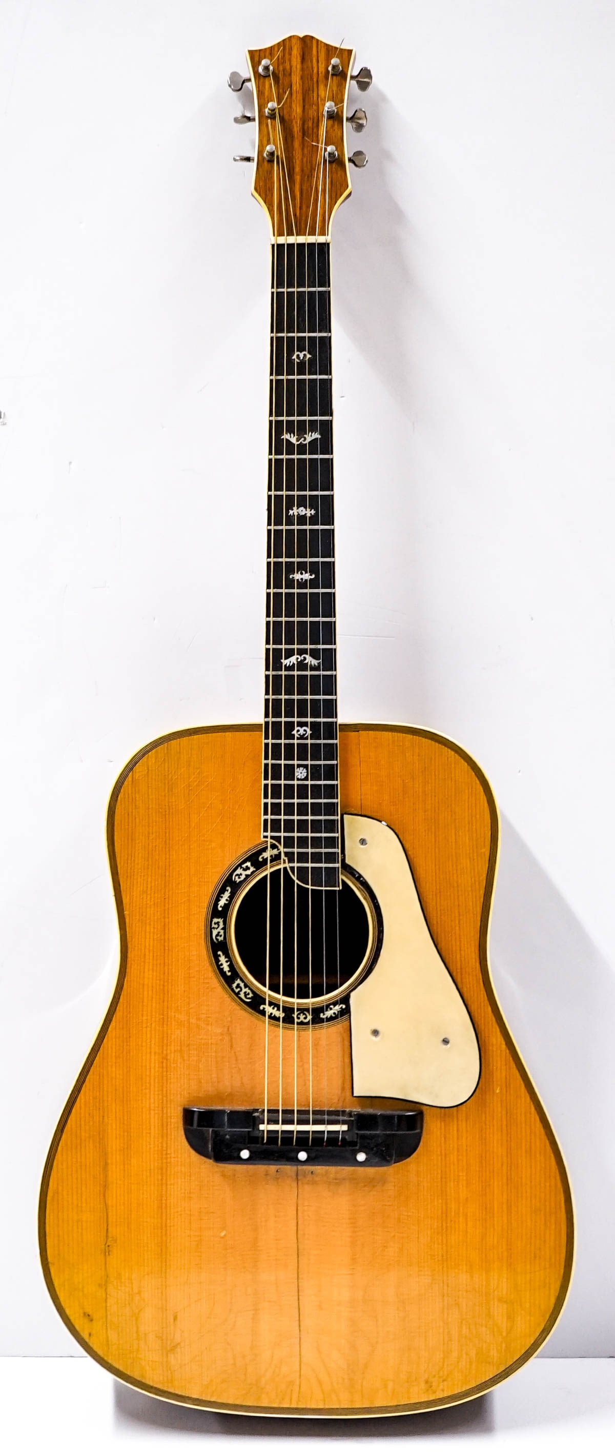 Acoustic Guitar: Unmarked, heavily played. Measures 42 x 16 x 5.75 inches. There is a split (or crack) on front to the wood. The absence of a condition report does not imply that the lot is in perfect condition or com
