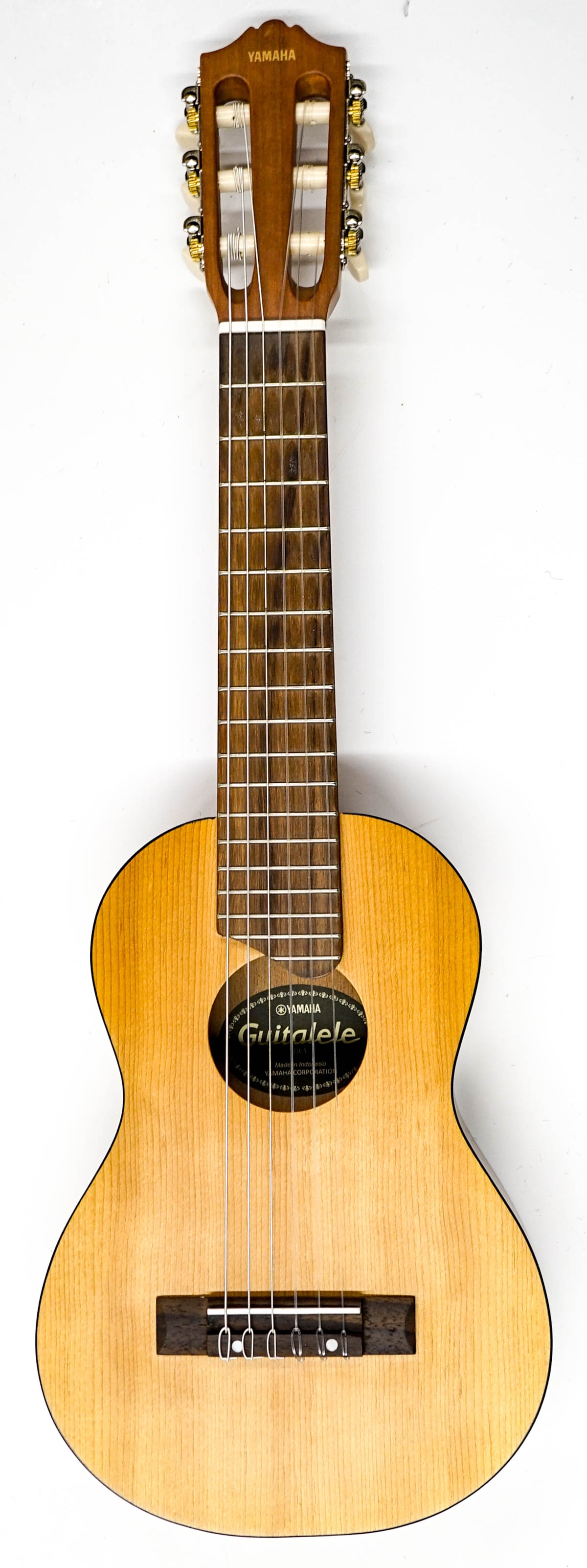 Yamaha Guitarlele Model GL1: EX/EX+ condition. Measures 27.75 x 9 x 2.75 inches. Includes a soft case. The absence of a condition report does not imply that the lot is in perfect condition or completely free from wear and tear, i