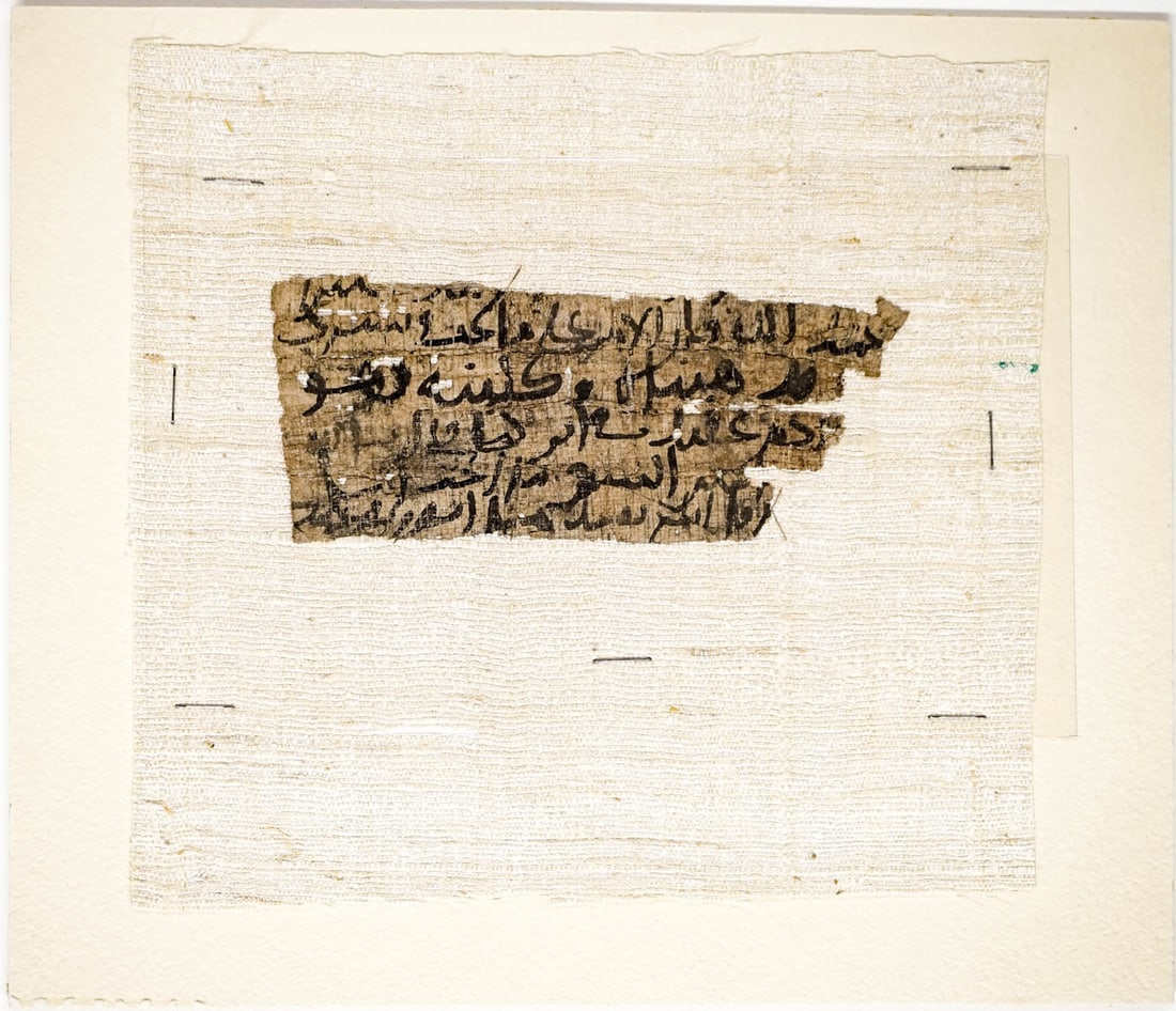 [Papyrus, Qur'an, Arabic] Fragment: [Papyrus, Qur'an, Arabic] Fragment. Unframed, mounted to linen, then mounted to mat board. Measures 5.375 x 2.25 inches, mounted, measures 10 mx 8.5 inches. The absence of a condition report does not