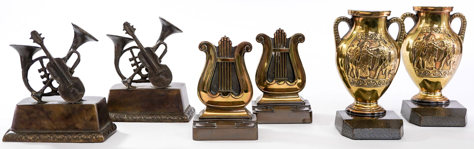 Vintage Bookends (3 Pair) Metal Bookends: Three (3) pair bookends. 1) Greek Urn. EACH measures 7 x 4 x 3 in. 2) PMC 56B Harp Lyre. EACH measures 6x 4 x 2.5 in. 3) Musical Instruments. EACH measures 6 x 6 x 2.5 in. Group lot measures 15 x 10 x
