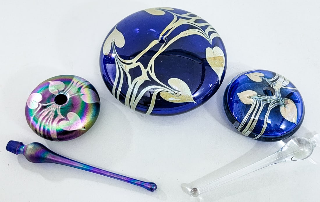 Glasshouse (3) Perfume Bottles / Oil Lamp Hearts: 1) Oil lamp measures 3 in. tall x 3.25 in. wide. 2) Perfumes measure approximately 7.5 in. tall with stoppers x 3.125 in and 3.5 in. wide. No evident cracks, chips or repairs. Measures 3 x 12 x 8 in.