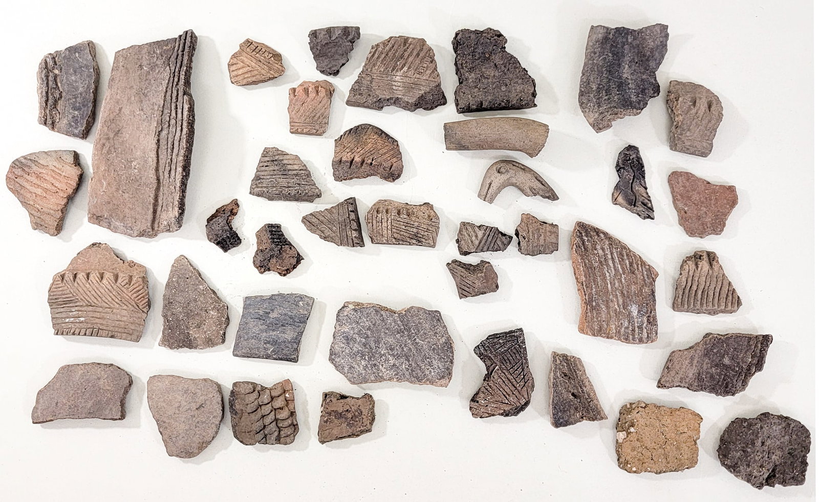 Old Pottery Fragments: Lot of pottery fragments measure 1.25 to 5.25 in. Lor measures 9 x 9 x 2 in. for shipping purposes only. The absence of a condition report does not imply that the lot is in perfect condition or