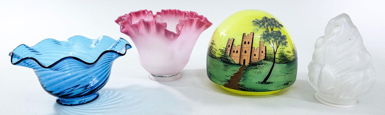 Assorted (4) Vintage Glass Lamp Shades: 1) Frosted measures 5 in. tall x 2.125 in. across rim. 2) Pink measures 4.5 in. tall x 6.25 in. across base and 2.25 in. across rim. 3) Blue measures 3 in. tall x 6 in. across base and 2.125 in. acros