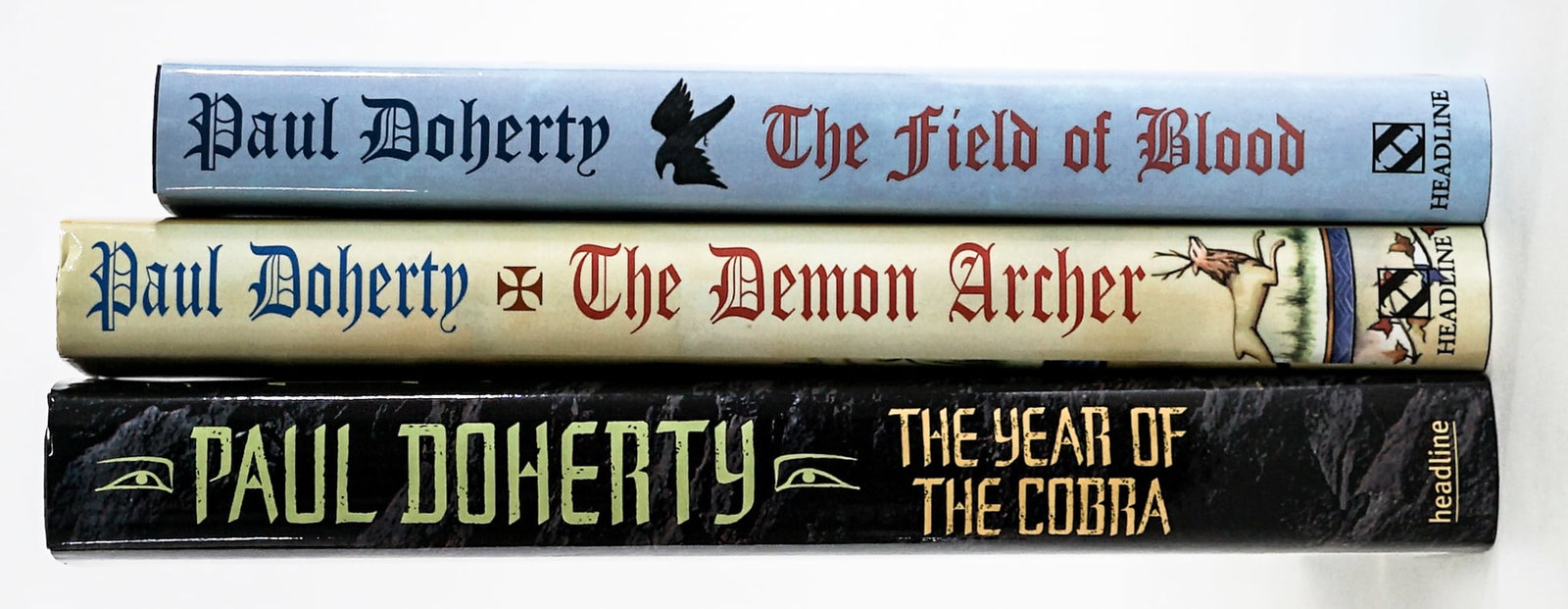 Paul Doherty (3) SIGNED 1st Editions: Three (3) 1st edition Paul Doherty books all signed on title pages with unclipped dust jackets. Headline Book Publishing. Includes: The field of Blood 1999; The Year of the Cobra 2006; The Demon Arche