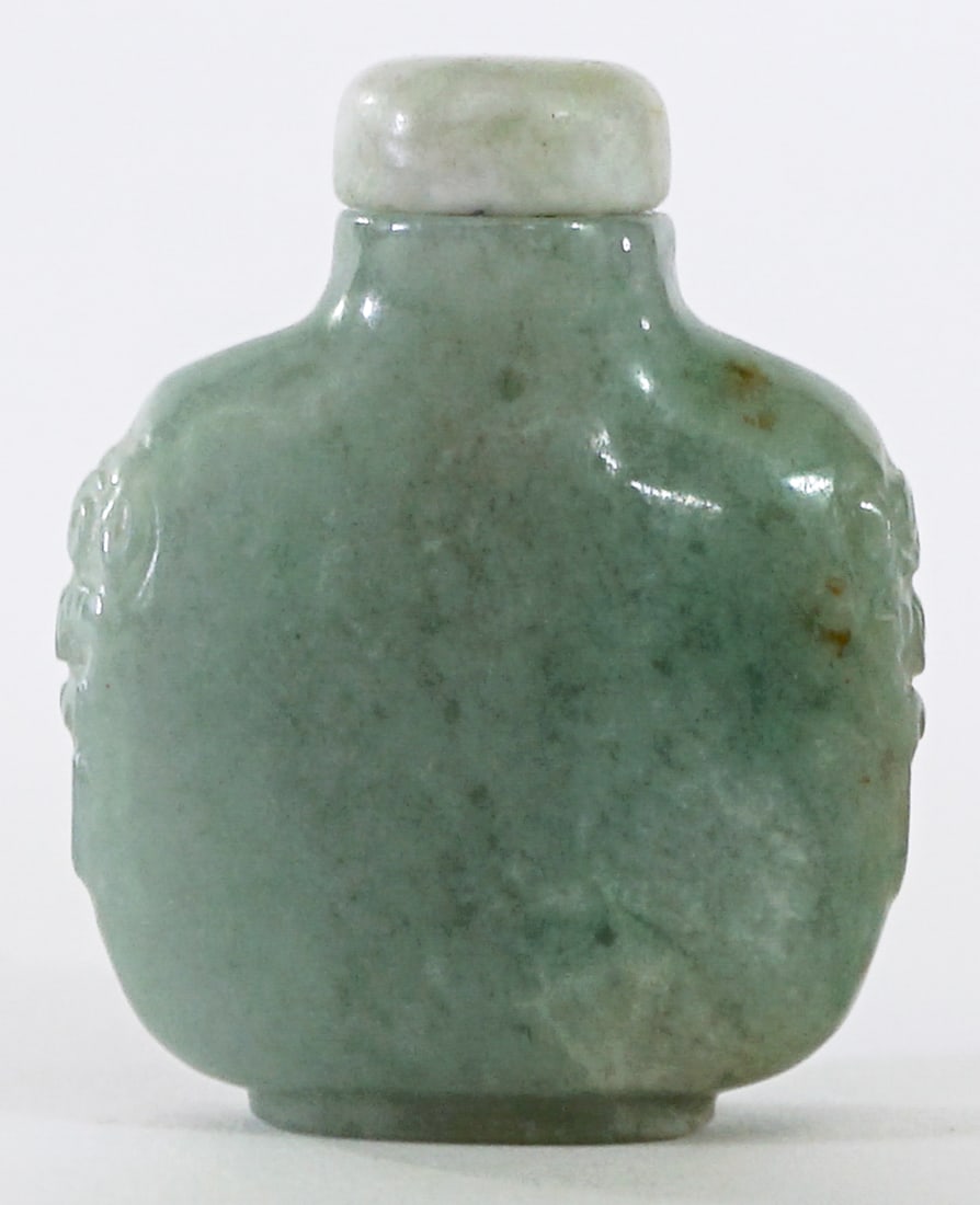 Chinese Carved Jade Snuff Bottle: Chinese Carved Jade Snuff Bottle with snuff spoon stopper measures 2.5 in. tall x 1.875 in. wide x .75 in. deep. No evident cracks, chips or repairs. Lot measures 2.5 in. H x 1.875 in. W x .75 in. D