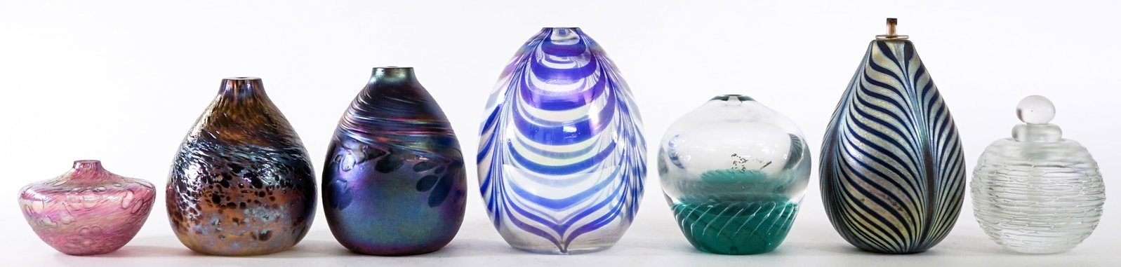 Assorted (7) Art Glass [Oil Lamps / Perfume]: Assortment of seven (7) studio art glass pottery items. Several artist signed. Measure 2 to 4.75 in. high. No evident cracks, chips or repairs. Lot measures 4.75 in. H x 9 in. W x 9 in. D for shipping