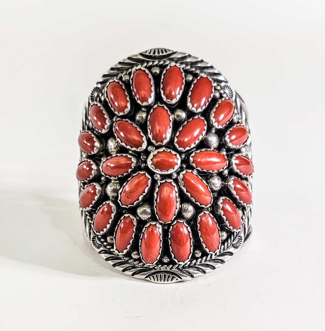 Charles Johnson Sterling / Coral Cuff Bracelet: Charles Johnson signed sterling coral cluster cuff bracelet measures 7 in. wide x 3.25 in. high. Inside circumference measures 5.5 in. total 6.5 in. Weighs 158 grams. Lot measures 3 in. H x 3 in. W x 