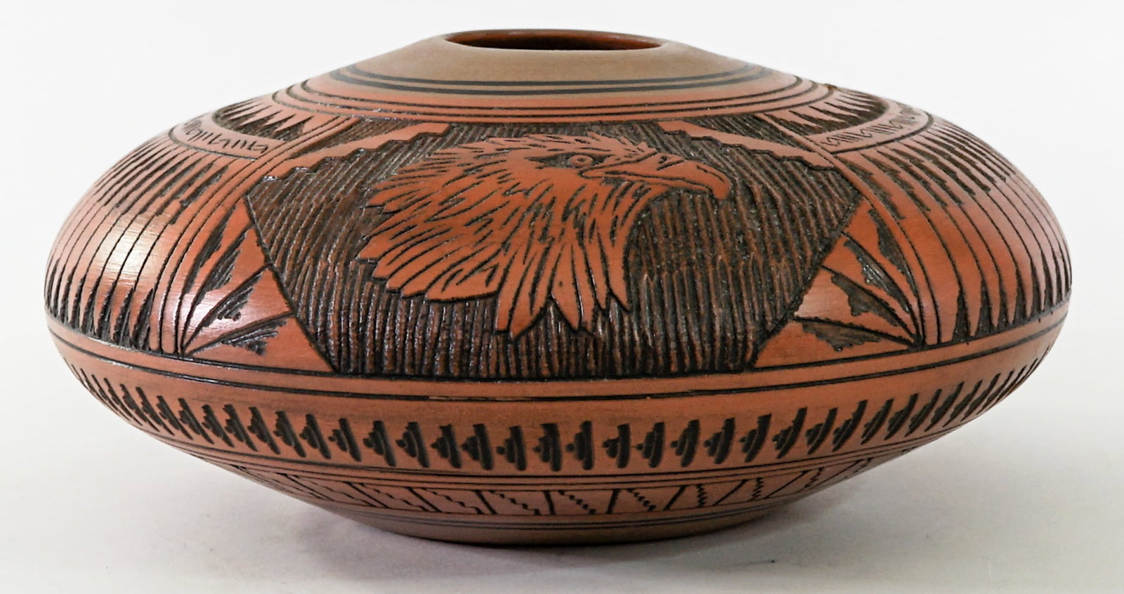 Ernest Watchman Jr. (Navajo) Pottery Vase [Eagle]: Ernest Watchman Jr. (Navajo) pottery vase artist signed underside. Two (2) small chips, see photo. Measures 5 in. tall x 10.5 in. wide. Lot measures 5 in. H x 10.5 in. W x 10.5 in. D for shipping purp