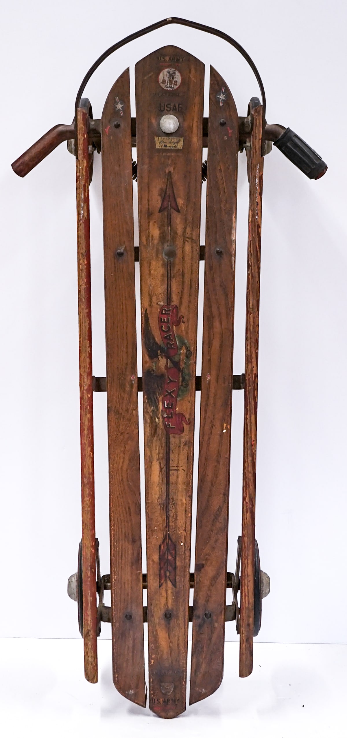 Antique Flexible Flyer Wood Sled: Measures 43 x 15 x 14 inches. There are United States Military decals added and names written on underside. The military decals may be from model kits. The absence of a condition report does not