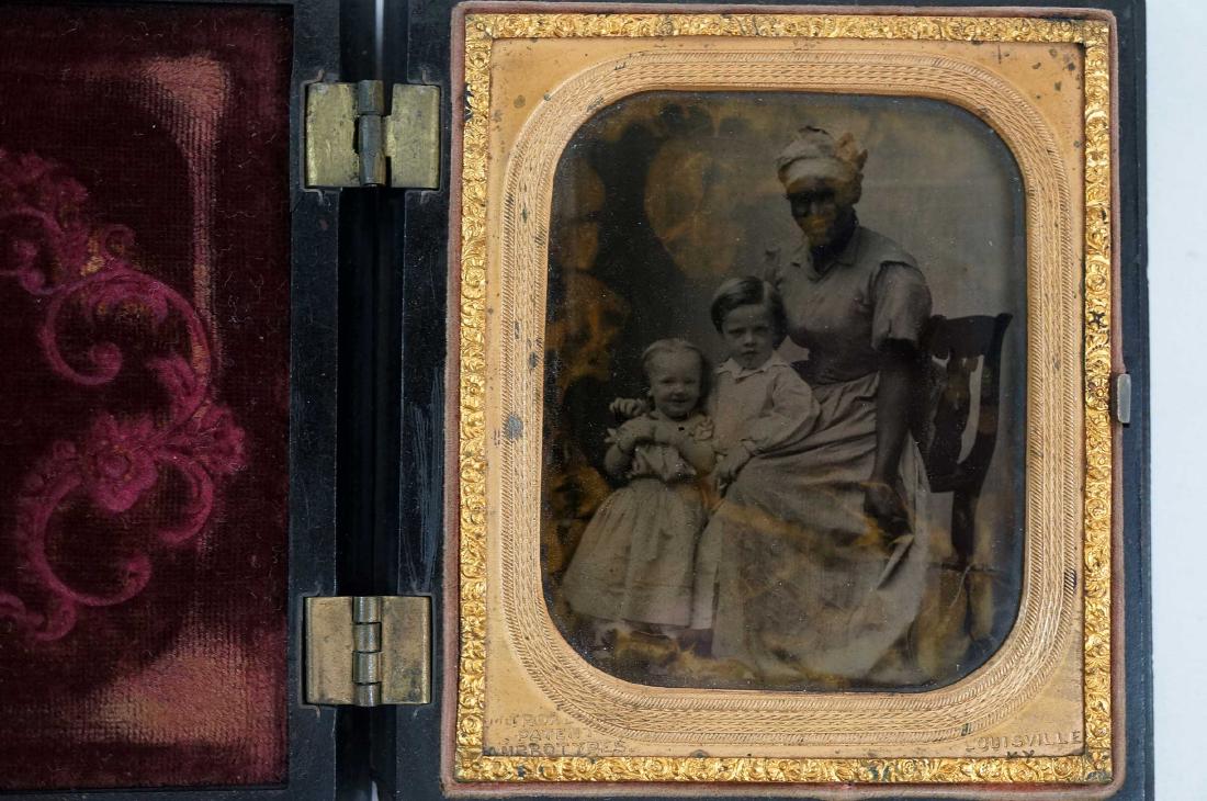 African American Nanny and Children Ambrotype: African American nanny with two children she cared for. As seen with spots. 3-1-4" x 2-3/4". Auction Gallery Notes: Condition: If the auctioneer does not provide a statement of condition in the items 
