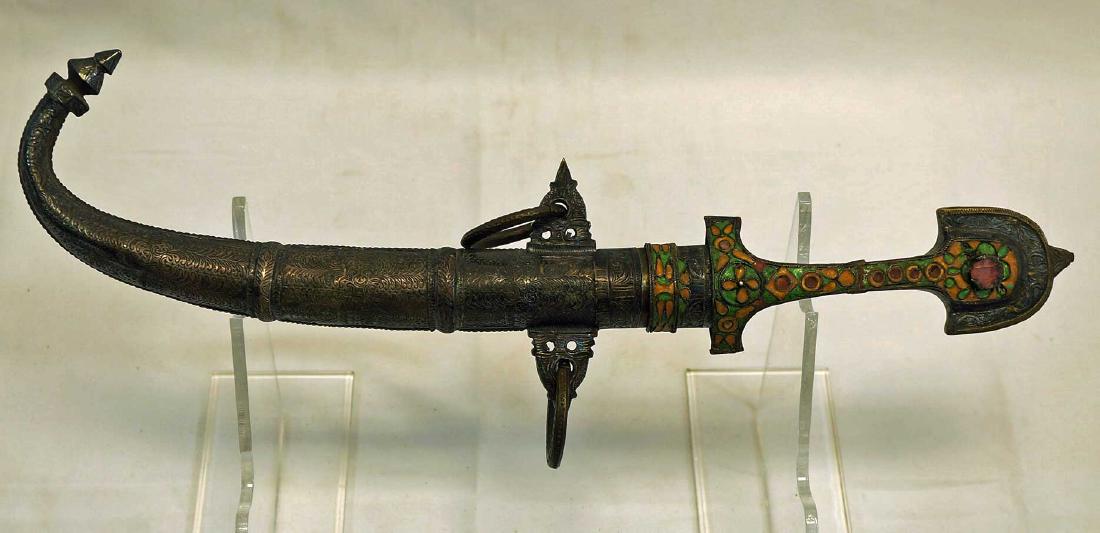 Moroccan Koummya dagger with scabbard.: Moroccan Koummya dagger with scabbard, early 20th century. Brass with engraved silver inlay and paste enameled handle. 10” blade, 16.5” overall. Auction Gallery Notes: Condition: If the auctioneer