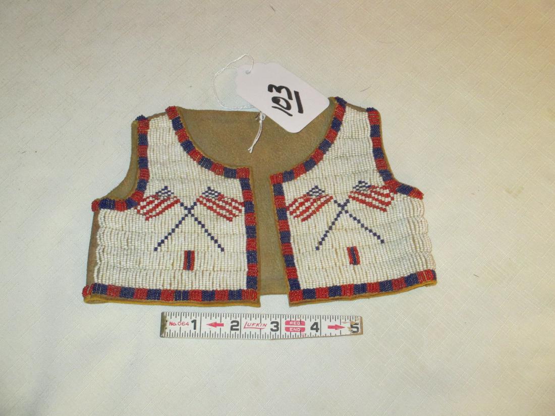 Sioux vest: Sioux flag beaded baby vest, 9" wide, sinew, soft, before 1940