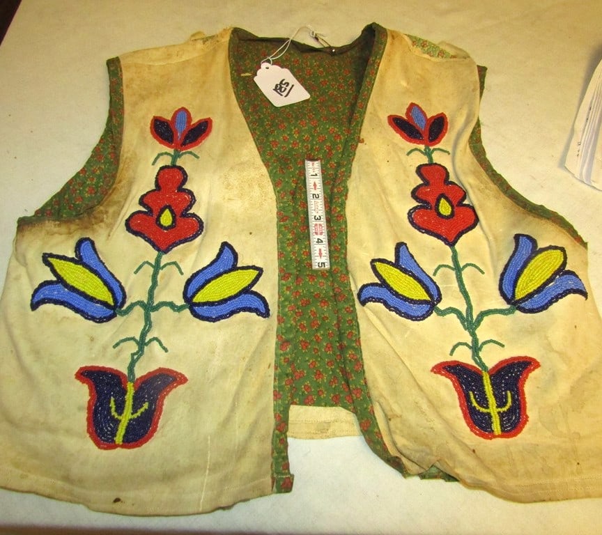 Vest: Large floral beaded vest, brain tanned, torn neck area, some stains, poor to fair condition,