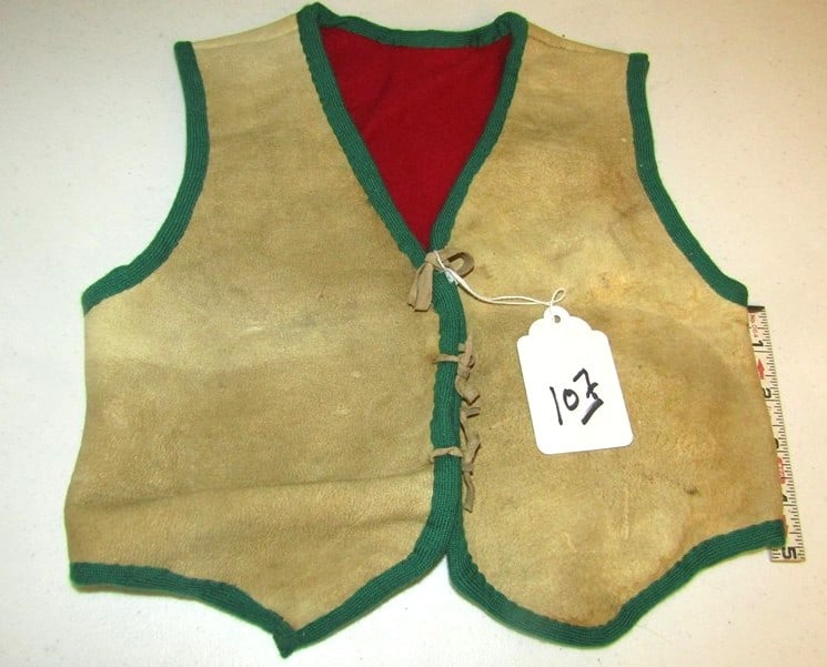 Vest: Child's hide vest with cloth lining and hide ties, very good condition