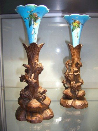 Pair Blue Glass & Carved Wood Trumpet Vases: c.1900 with carved wooden trunk form bases. The epergnes with hand enamelled floral dec. Height 27cm