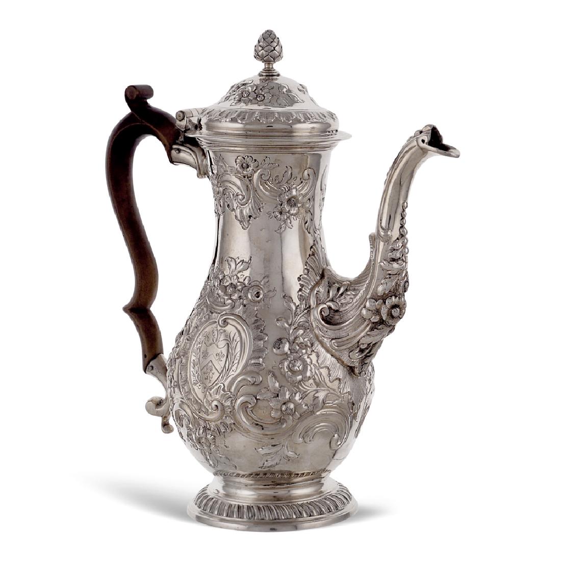 Silver coffee pot London, George III, 1761: weight 969 gr. John Stewart goldsmith, pear shaped body chiselled with floral and vegetal paterns, centered by a heraldic crest, shaped wooden handle, h. 28 cm.