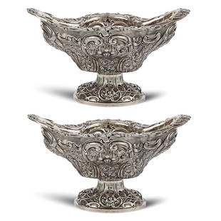 A pair of silver stands London, Giorgio III, 1811: mark of William Bennett, body embossed and chiselled with floral and vegetal motvies, slight defects, 15x27x22 cm.