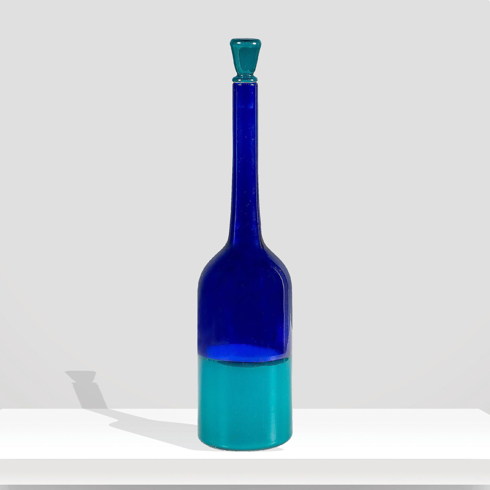 Venini Murano, 1982 h. 31 cm.: Incalmi series blue blown glass bottle with green opal glass bottom and stopper, signature Venini Italia 82 under the base, old labelsCatalogo originale Venini 1969, pag. 32