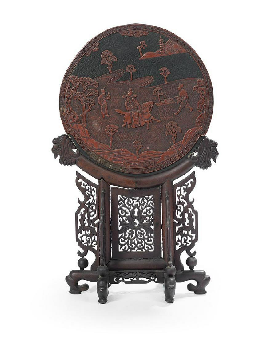 Asian Chinese Cinnabar and Black Lacquer Table Screen: the screen of circular form, decorated to one side with two ladies at leisure in a garden setting, and to the other with a representation of the emperor on horseback with two attendants, Xuande mark w