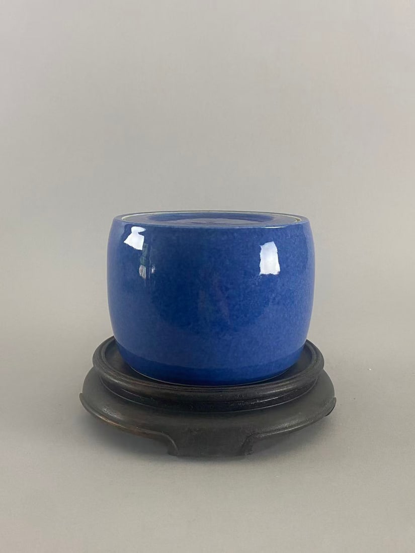 Chinese Antique Monochrome Powder Blue Porcelain Covered Jar | Xuande Mark | Hardwood Stand: Chinese monochrome powder blue glazed porcelain covered jar, elegantly potted in a classic cylindrical form with matching fitted cover. The vessel is covered in a rich, luminous sapphire-blue glaze of