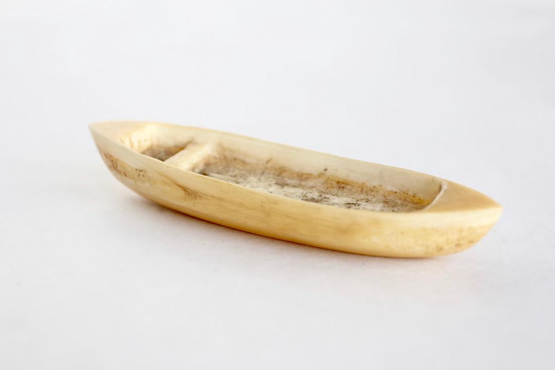Inuit Model Kayak: A model well fashioned Inuit Kayak fashioned of bone, likely a child's toy. 4 in. x 1 in. / 10.75 cm. x 2.5 cm. 1920-50