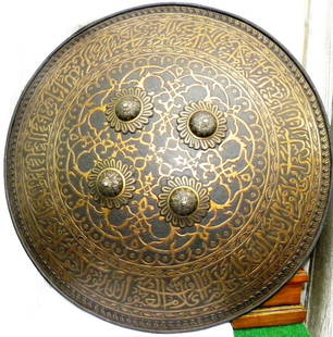 AMAZING ORNATE PERSIAN MILITARY WARRIOR SHIELD ARABIC INSCRIPTION: Indo Persian Islamic convex form circular shield Arabic inscription. Made of hand forged steel , hand hammered & chiseled. The shield bears an elaborate chiseled engraving over its entire surface