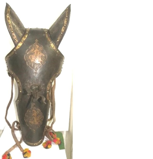 A COLLECTOR CHOICE PERSIAN WARRIOR WAR HORSE MASK 2 WARRIORS ON HORSE BIRDS CENTER TRIDENT: INDO PERSIAN WARRIOR HORSE FACE MASK FIGS & 5 WAY TRIDENT , TWO WARRIORS ON HORSE FIGURES CHISELED AND ENGRAVED.Province : Indo Persian.Made : Made of hand forged steel, hand hammered and chiseled.Cen