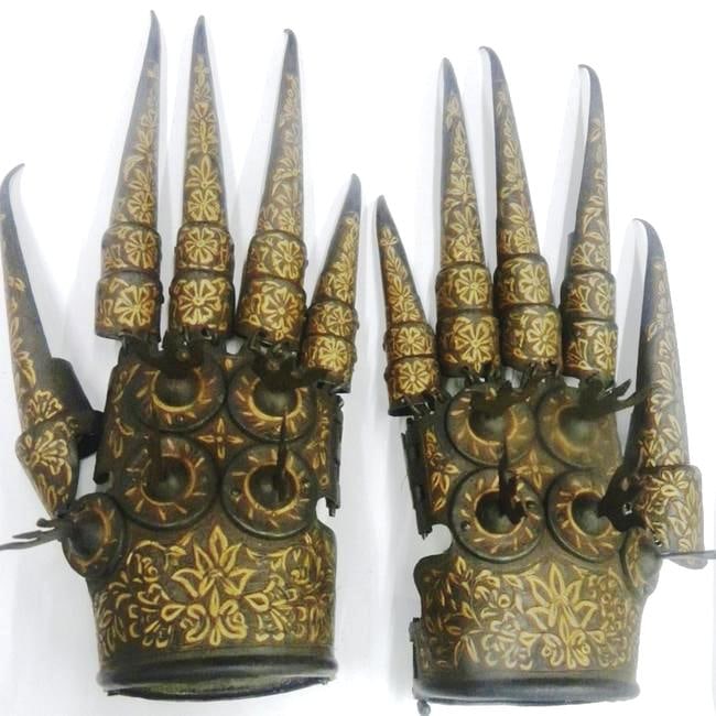 ORNATE ANTIQUE CLAW GAUNTLETS PAIR 3 WAYS TIDENT INSERTED Description:: A striking pair of ceremonial claw-shaped gauntlets crafted from aged metal, featuring long pointed talons and intricate floral engravings in rich gold and bronze tones. The detailed patterns and symm