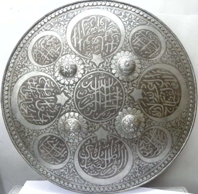 INCREDIBLE SHIELD MANNUAL NICKLE ARABIC CALLIGRAPHY HALF MOON EIGHT WITH CENTRAL PANEL CALLIGRAPHY: Incredible rare to find shield with half moon and calligraphy.Made : Made of hand forged steel , hand hammered and hand chiseled. Mughal / Islamic warrior shield, manually nickel with Arabic inscripti