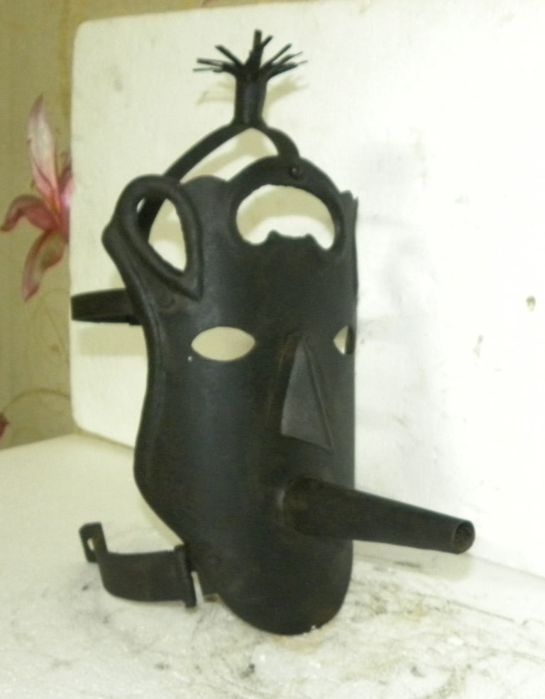 PUNISHMENT MASK FLUTE HAIR BAD MUSICIAN STEEL HAND FORGED: Beautifully hand made steel mask with flute is a symbol that he plays very bad flute and is a bad musician. There are steel hair also on top.After making wear this mask was tied on pole or tree in pub