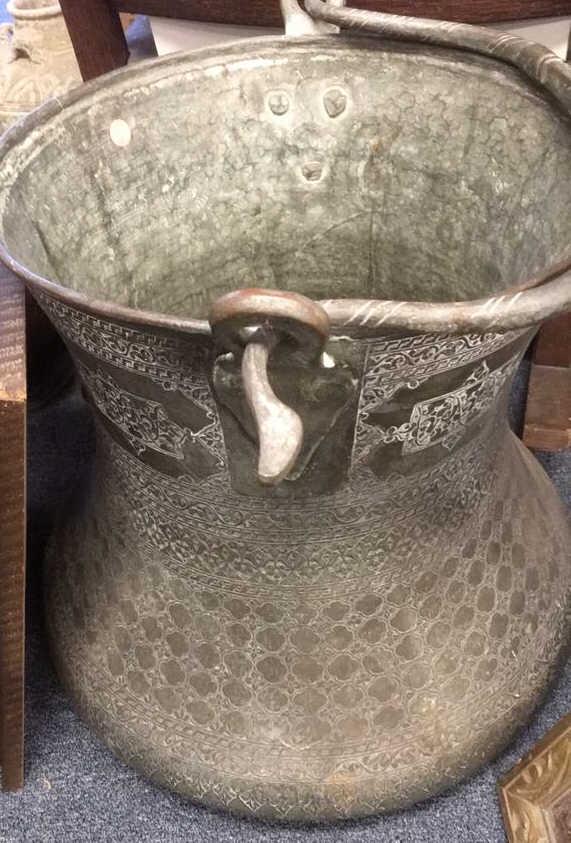 LARGE CAST IRON SOUTHEAST ASIAN CST IRON BRONZE VESSEL: WITH METAL HANDLE, 19th or 20 th century. Chased to depict floral decoration.Floral decoration. Size: 20.75 x 20 in. Unframed.