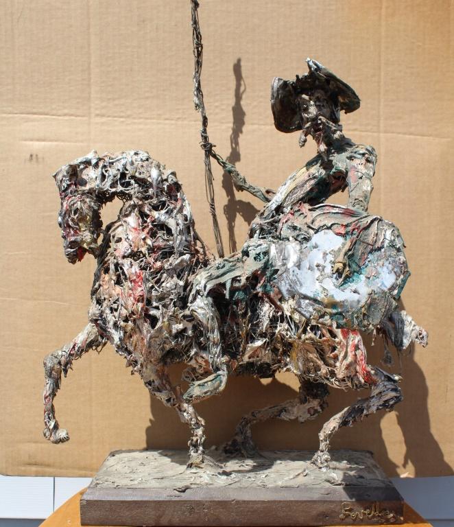 Don Quixote: Don Quixote. Metal sculpture of Don Quiote on horse with joust. Title: Don Quixote. Medium: Metal. Size: 28 X 18 X 12 in. Signature: Stamped in base. Artist: Revello. Unframed.