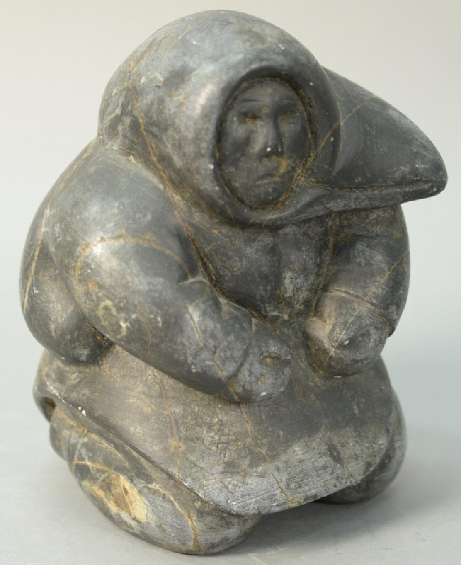 Inuit Eskimo carving possibly Kiakshuk or Lukta, Cape: Inuit Eskimo carving possibly Kiakshuk or Lukta, Cape Dorset dark grey basalt "Carving of an Eskimo" Sitting Inuit Woman (7 1/2in., 5 1/2in., 5 1/2in.).
