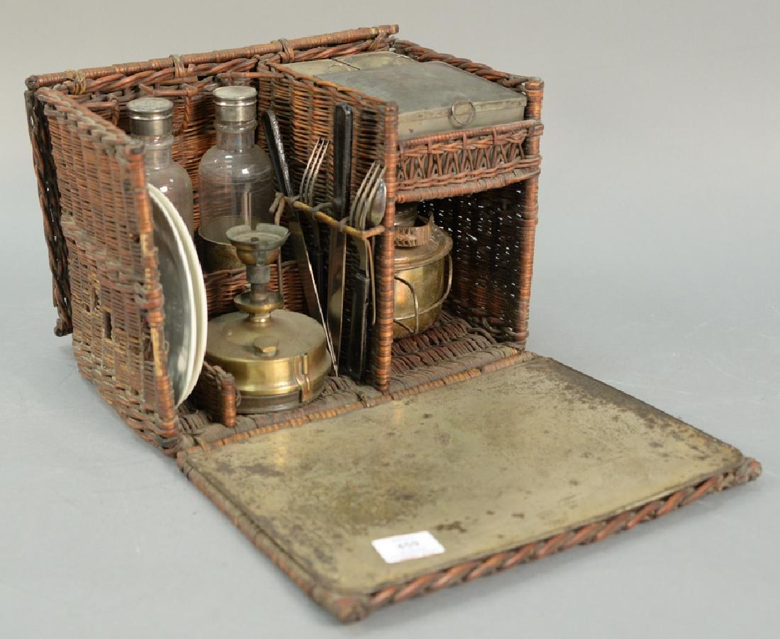 Drews En Route wicker picnic tea basket including: Drews En Route wicker picnic tea basket including bottles, plates, several containers, silverware, teapot, and burner. marked Drews & Sons 33 Piccadilly Circus London. ht. 10in., wd. 14in., dp. 10in. 