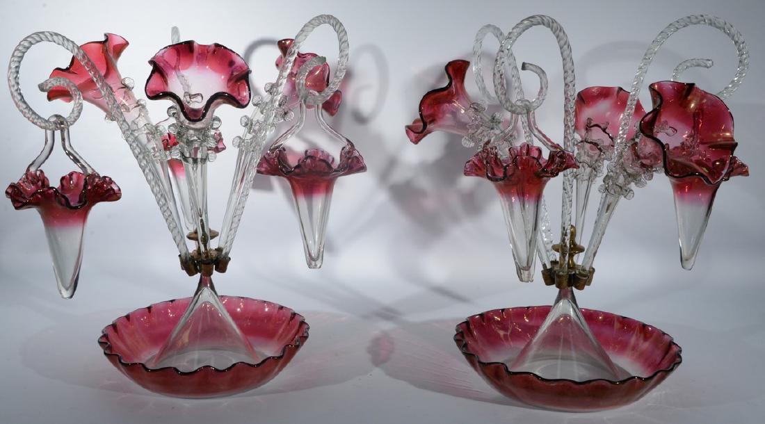 Two Victorian clear to ruby flash art glass epergnes: Two Victorian clear to ruby flash art glass epergnes having ruffle edge bowl with metal ring supporting three vases and three clear twist glass canes, two are supporting hanging vases. ht. 15 1/2in. P