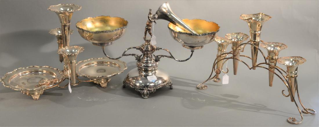 Three silverplate epergnes to include a silverplate: Three silverplate epergnes to include a silverplate epergne with two bowls and central putti supported by winged women, bottom band of birds and flowers (ht. 14in., wd. 24in.), silverplate epergne wit