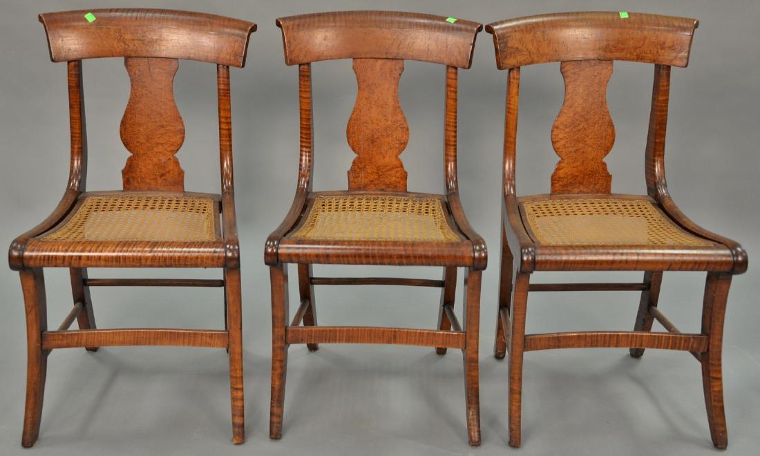 Set of three tiger maple cane seat chairs, circa 1840.