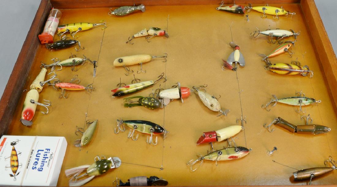 Twentyseven various vintage fishing plugs in display