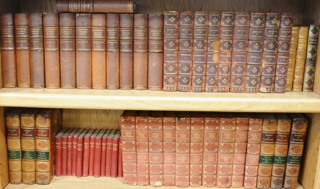 Large group of leatherbound books on seven book shelves (1 of 8)