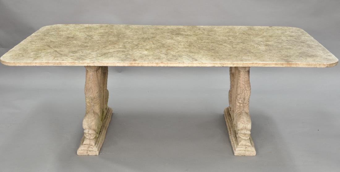 Outdoor table having marble top on base of two cement: Outdoor table having marble top on base of two cement double dolphin base. ht. 28 in., top: 41" x 81"