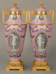 Pair of Sevres pate-sur-pate porcelain urns with: Pair of Sevres pate-sur-pate porcelain urns with covers, having gilt bronze finial on cover over gilt bronze mounted handles and central oval plaque with partially nude female enameled ribbon and wrea