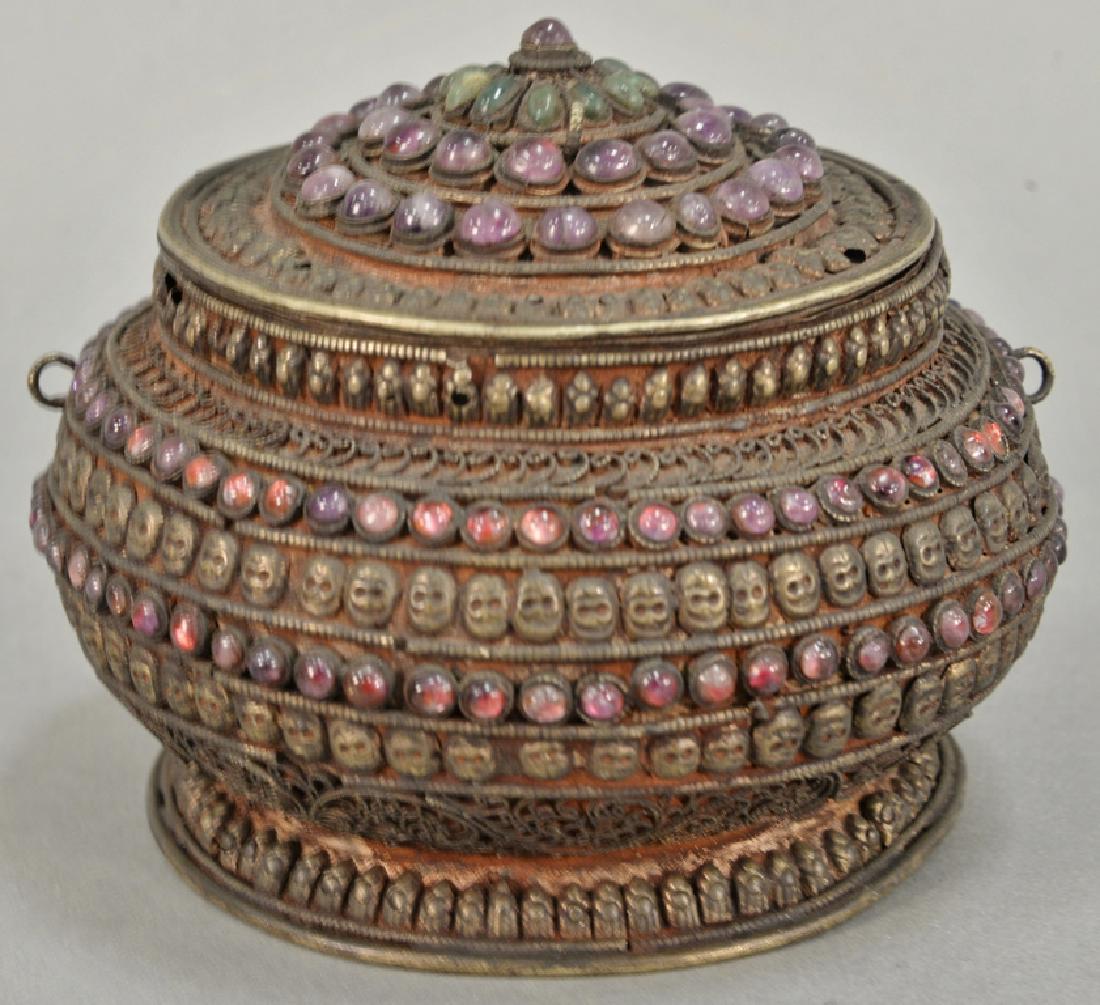 Early filigree covered box mounted with pink and green: Early filigree covered box mounted with pink and green beads and skull and skeleton embossed design. ht. 4 1/2 in., dia. 4 in. Provenance: Estate of Kenneth Jay Lane*IMPORTANT NOTE: No credit card pay